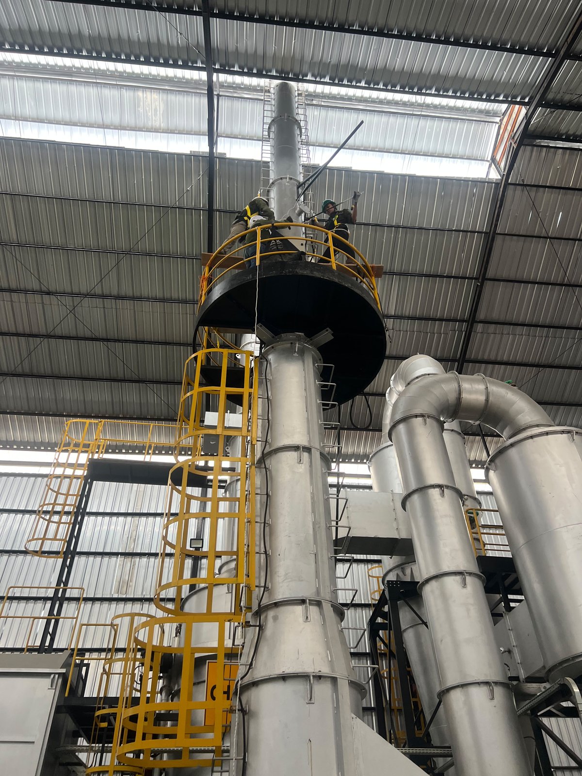 Tim bekerja di ketinggian platform cerobong incinerator